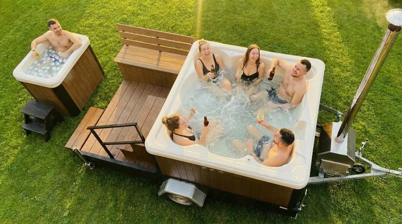 Przyjaciele relaksują się w balii z hydromasażem w ogrodzie